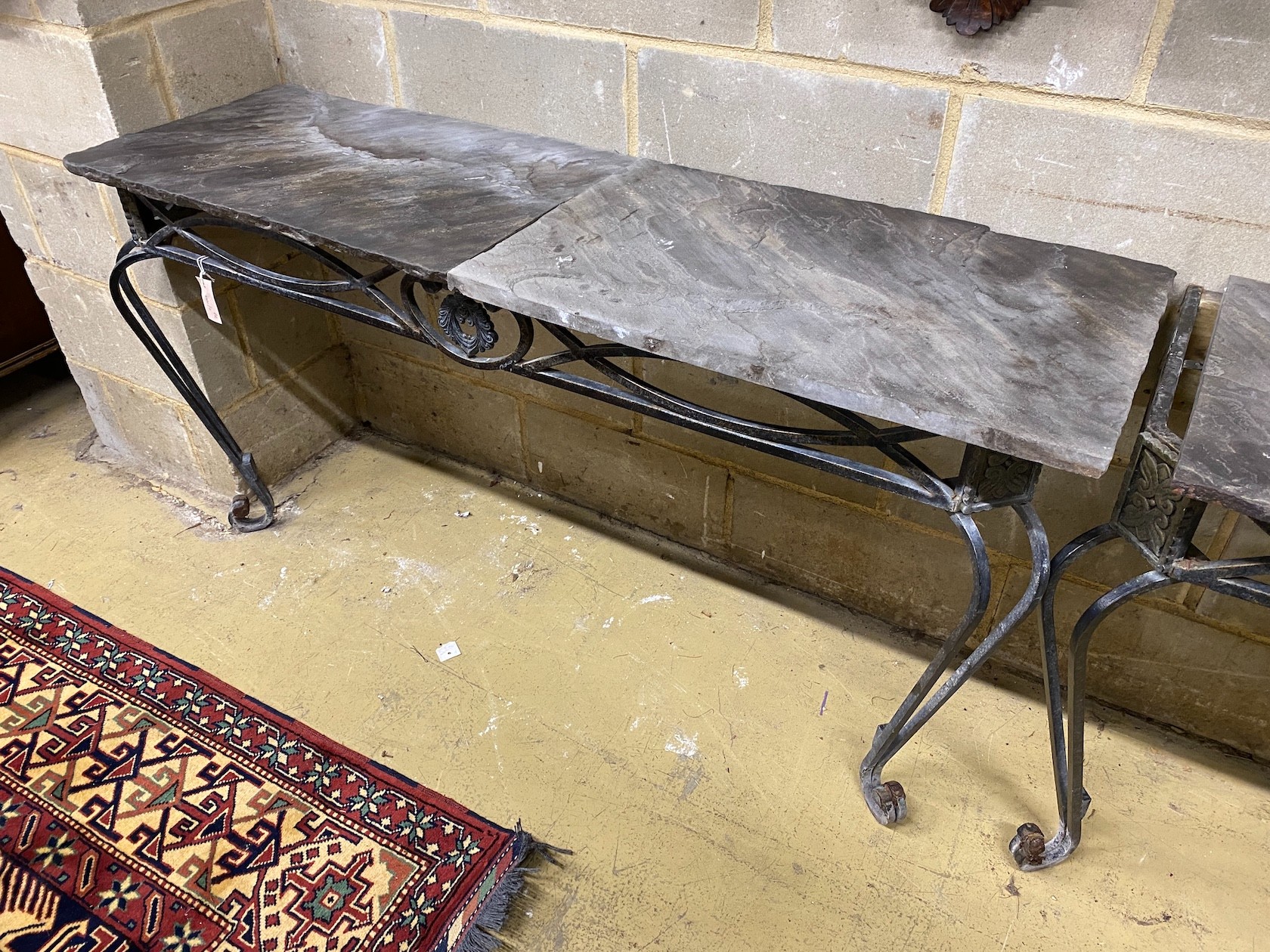 A pair of wrought iron slate top console tables, width 146cm, depth 45cm, height 75cm